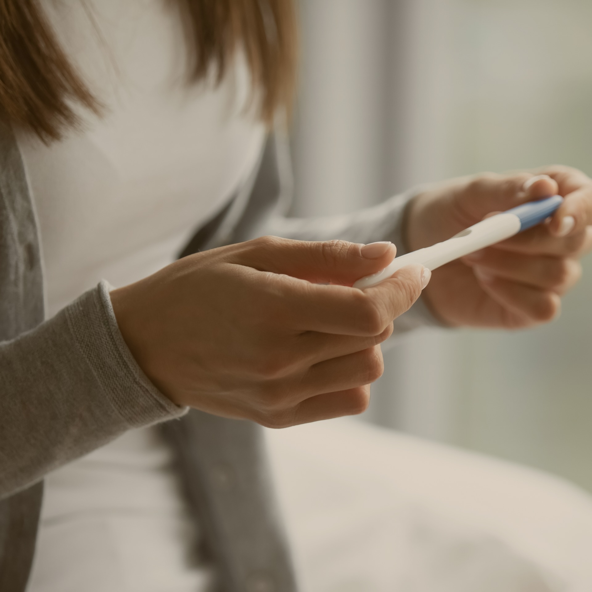 Woman holding a pregnancy test, and it symbolizes the journey and challenges of fertility and infertility